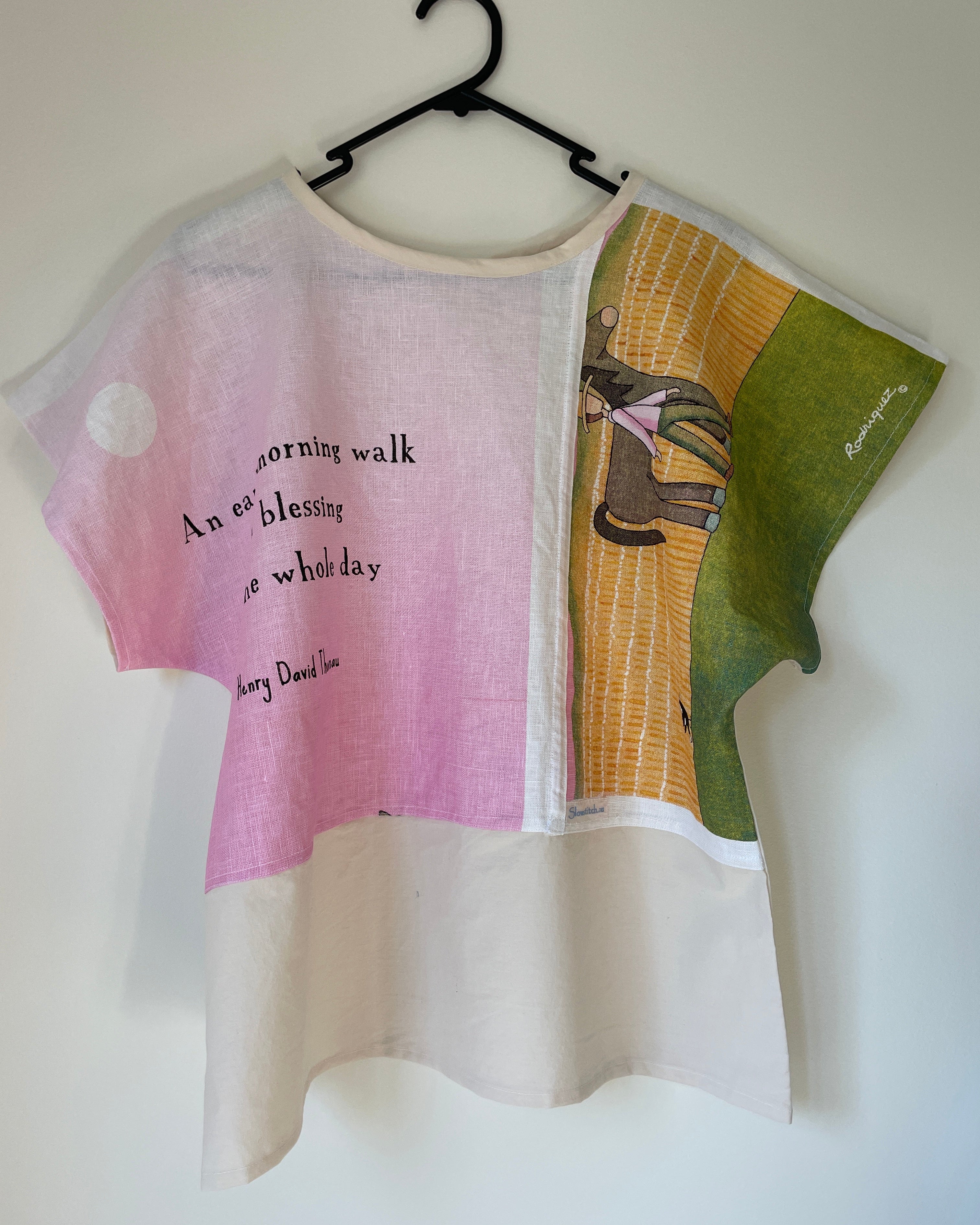 T-shirt with text and graphic design on a hanger against a white background