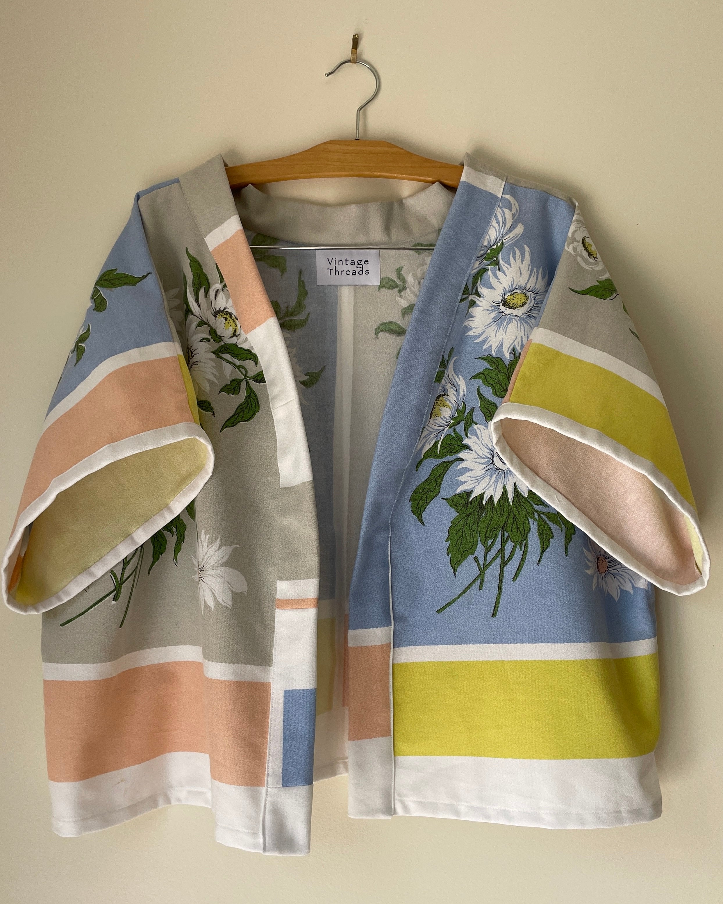 Floral-patterned kimono draped over a hanger against a plain background