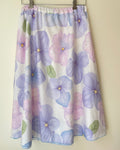 Floral-patterned skirt with purple flowers on a beige background