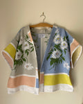 Floral kimono-style garment on a hanger against a beige wall