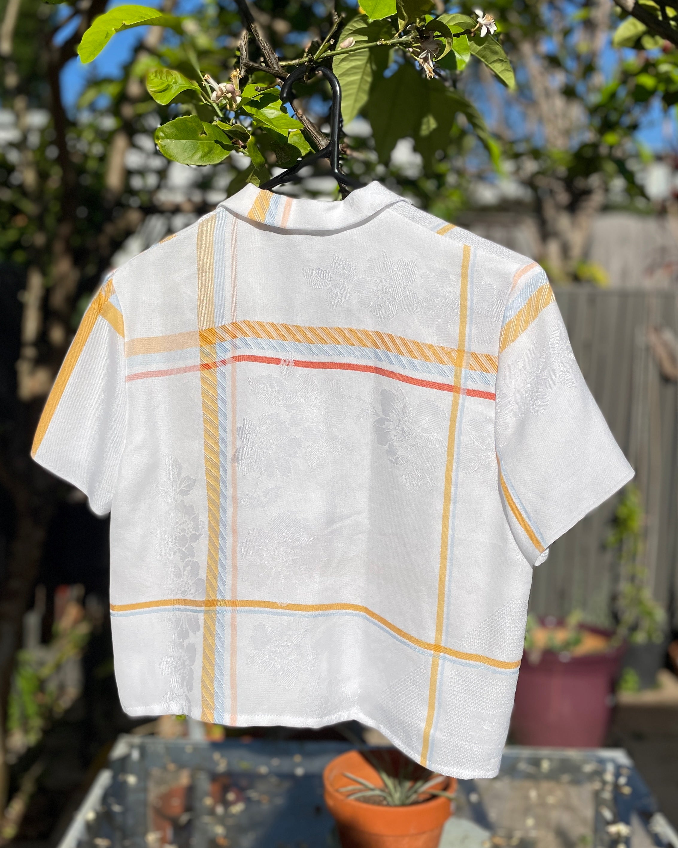 White shirt with yellow plaid pattern on a white background