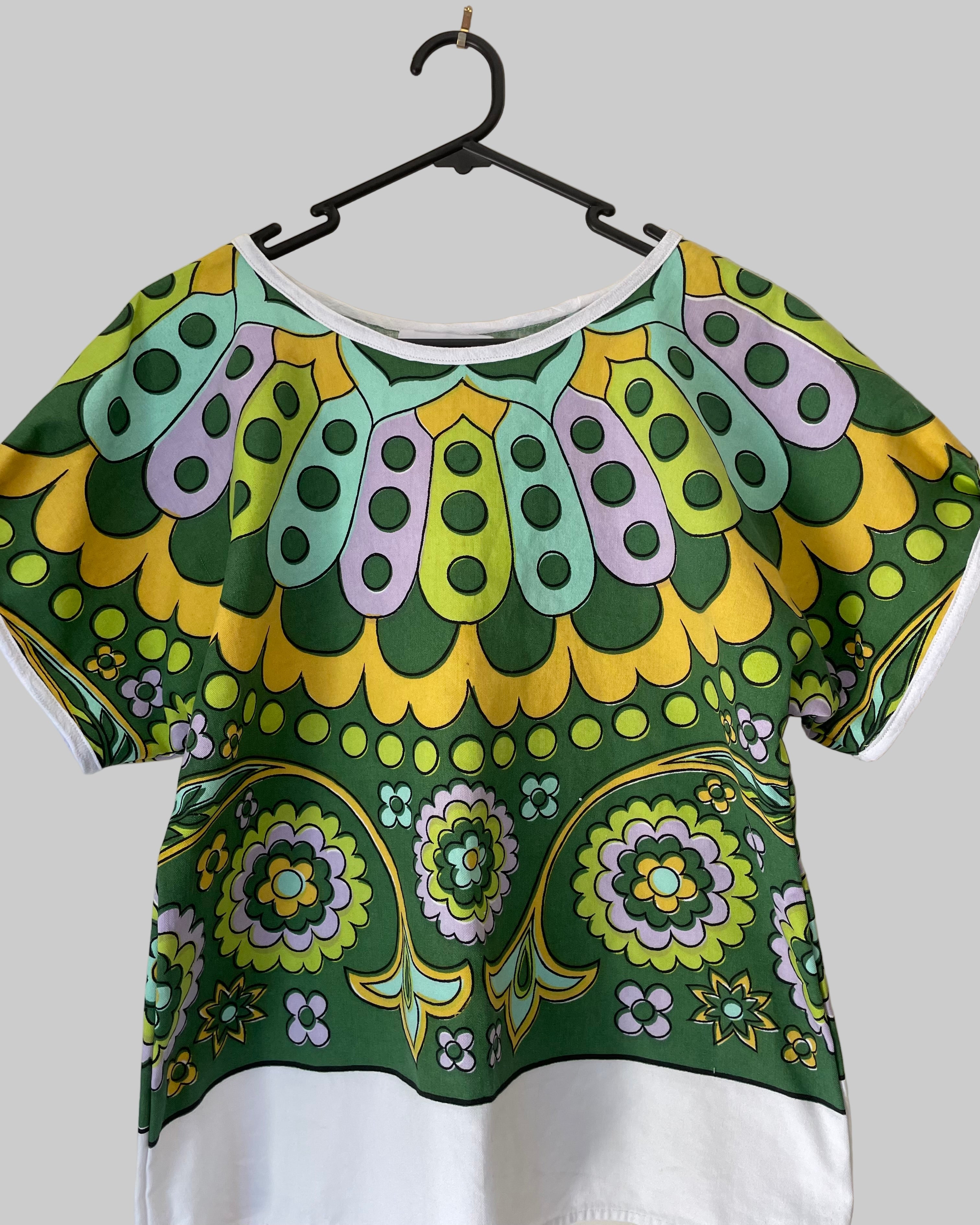 Colorful patterned top on a hanger against a white background