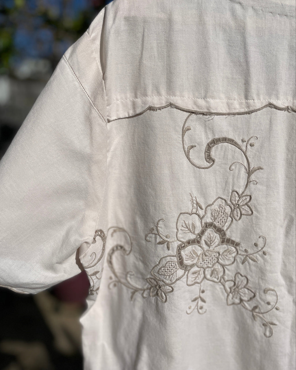 White shirt with floral embroidery on a blurred background