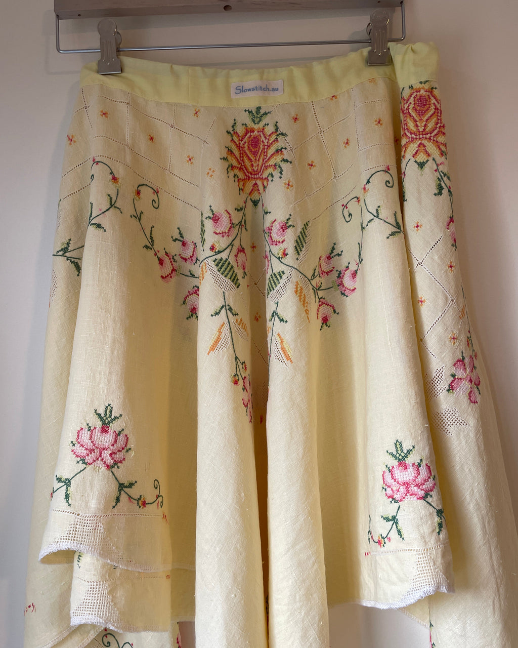 Skirt with floral embroidery hanging on a rack