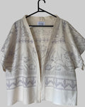 White kimono-style garment with gray floral patterns on a hanger against a white background