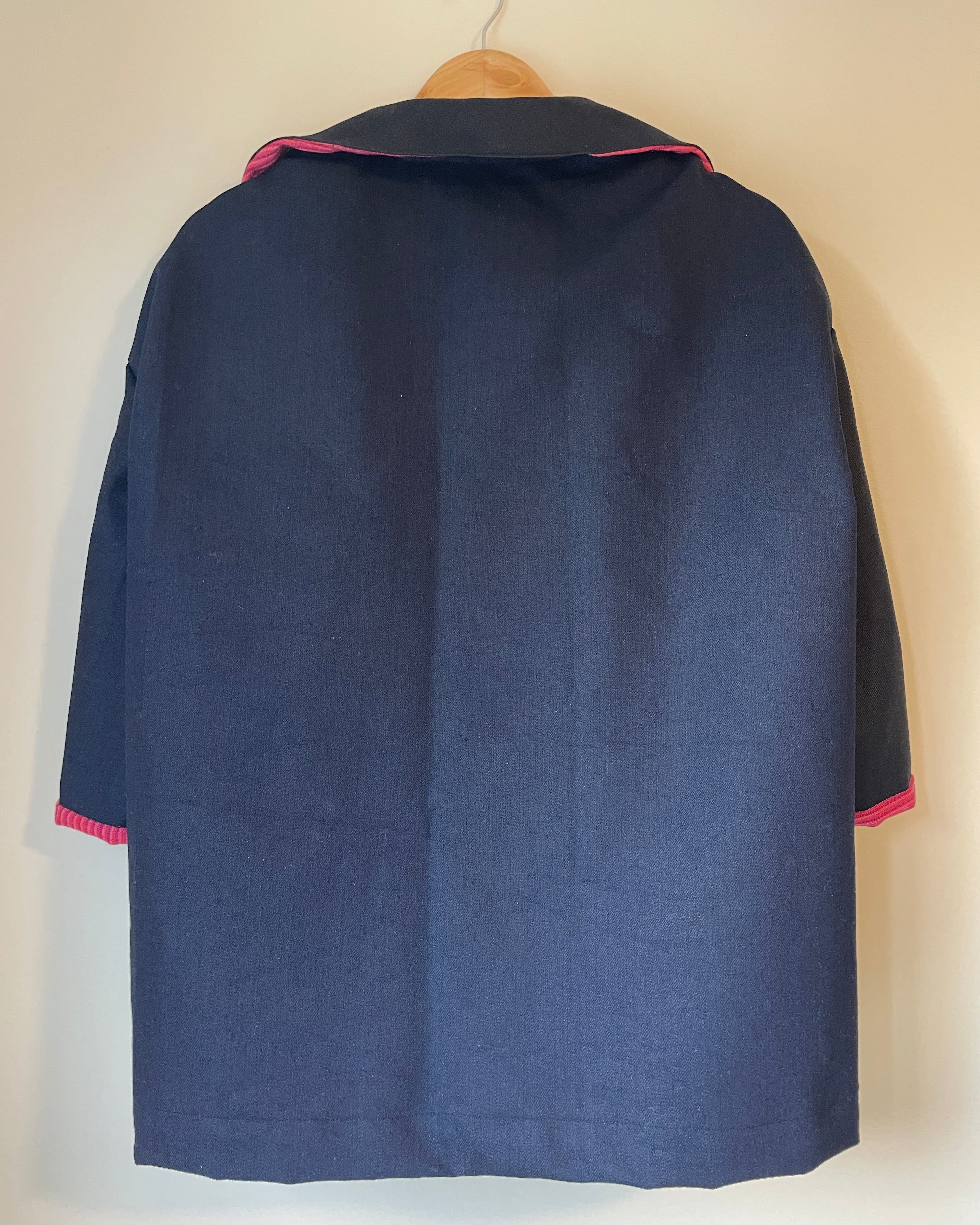 Navy blue jacket with red accents on a light beige background