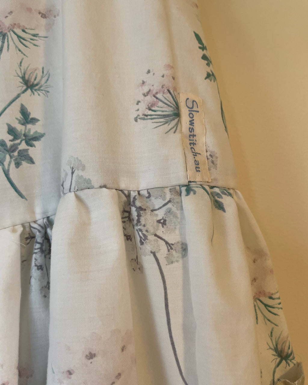 Floral-patterned fabric with 'Slowstitch' label on a plain background