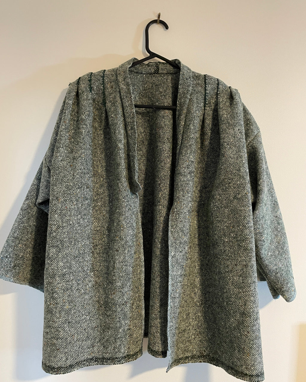 Folded gray woven coat on a light background