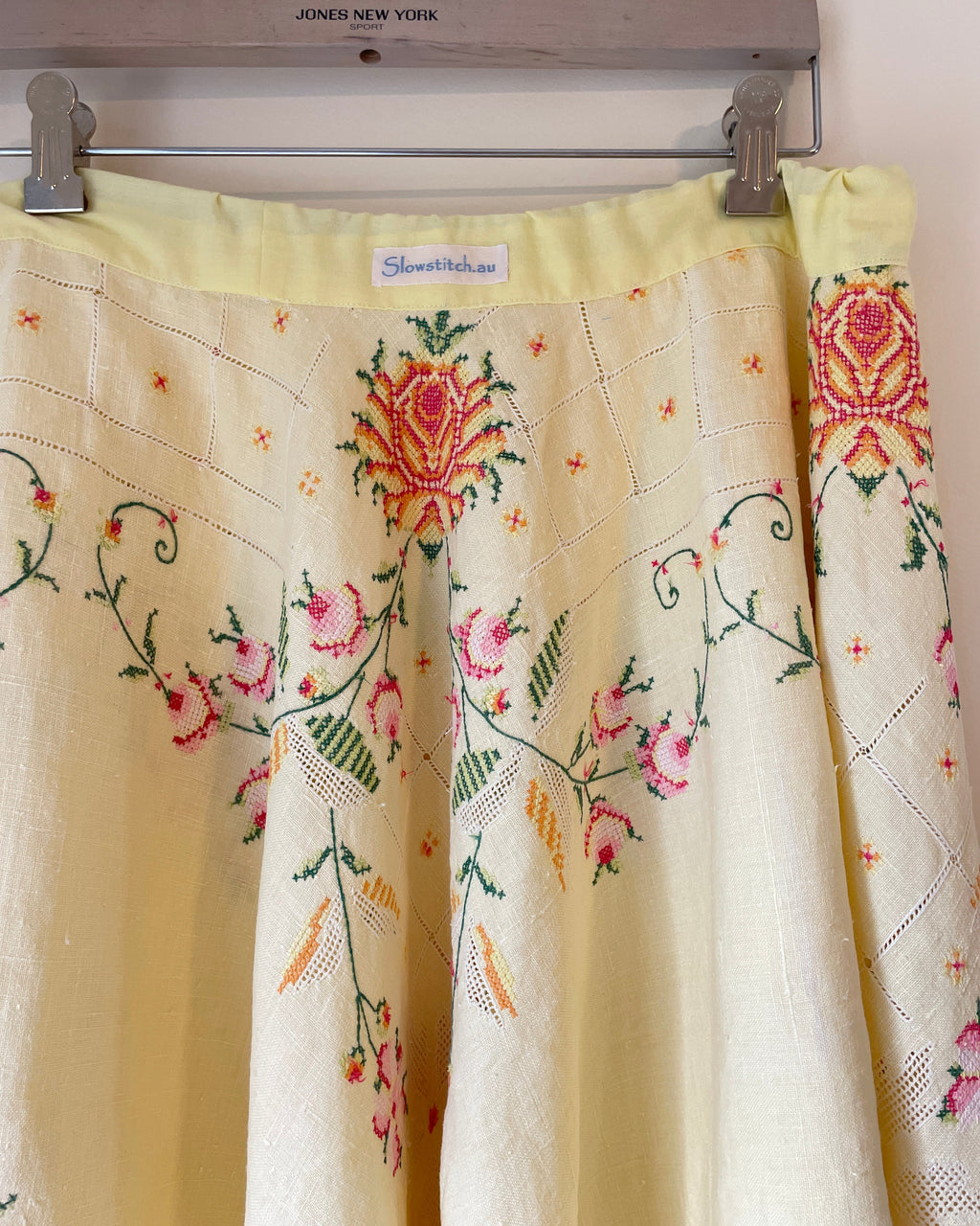 Embroidered fabric with floral patterns hanging on a rack