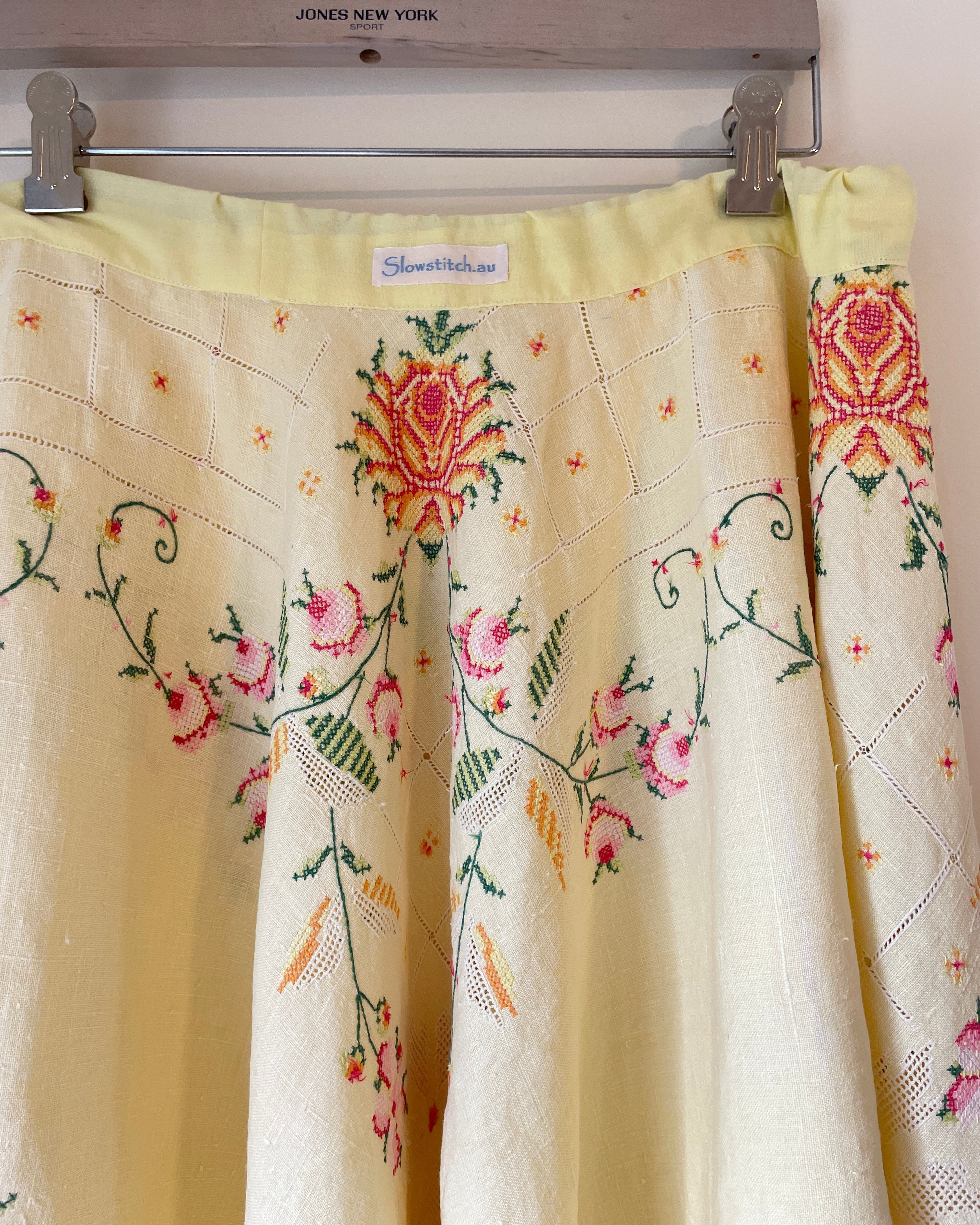 Embroidered fabric with floral patterns hanging on a rack
