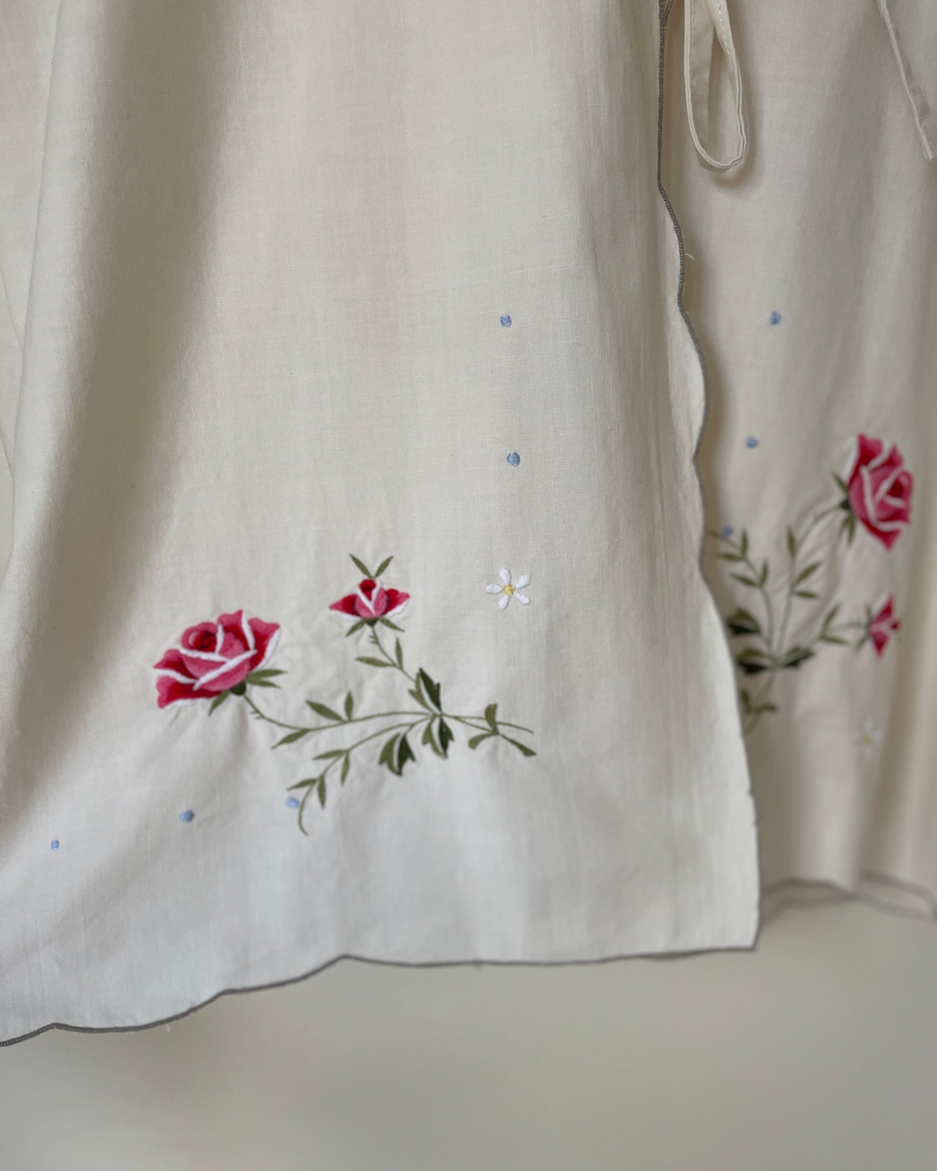 Embroidered floral design on a light fabric background