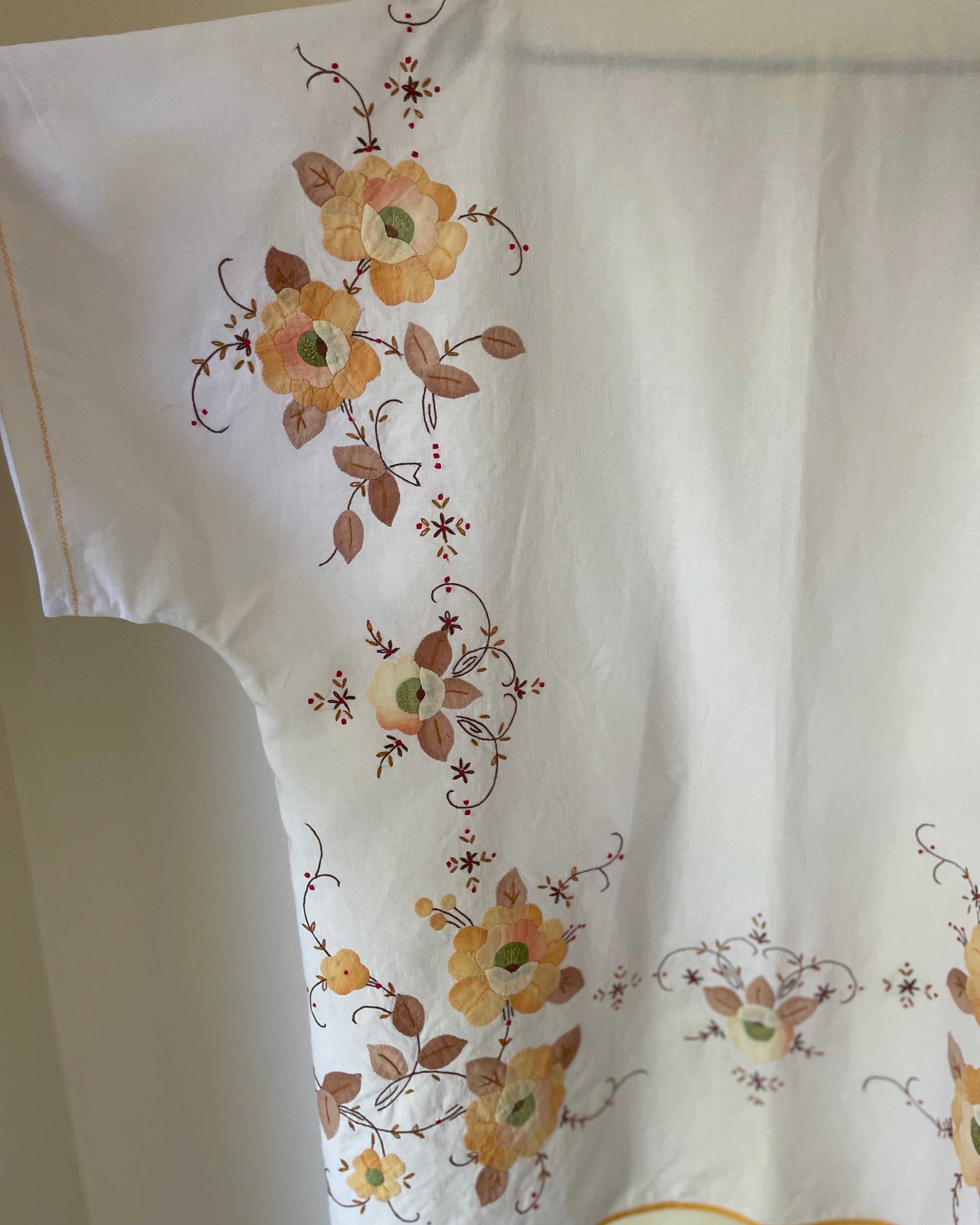 White fabric with floral embroidery on a plain background