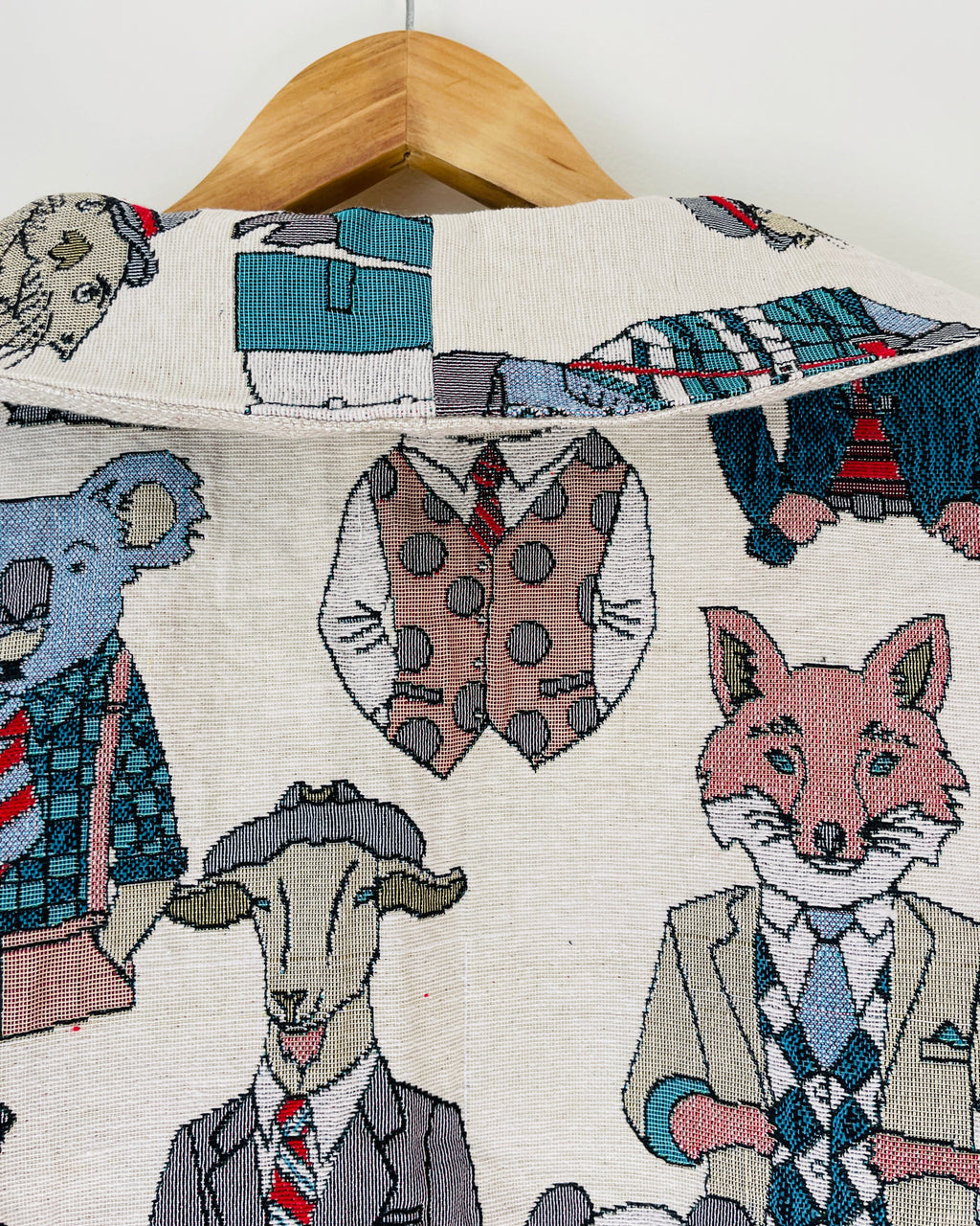Jaclet collar with animal-themed design featuring a fox, deer, and elephant in suits on a hanger.