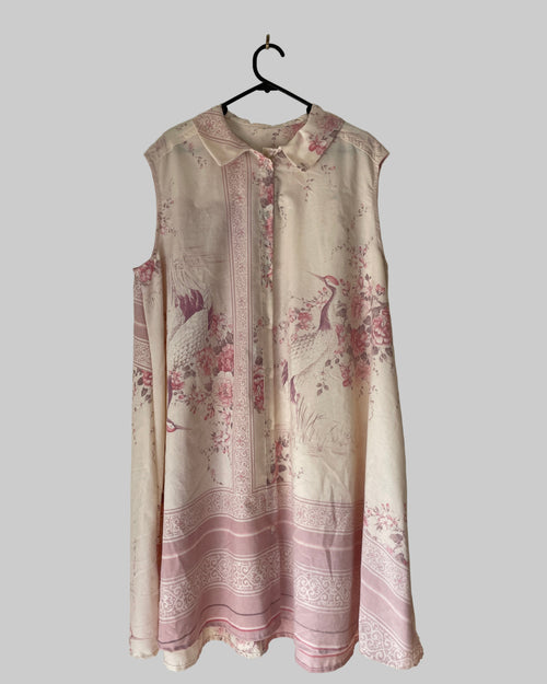 Floral patterned dress hanging on a hook against a plain wall.