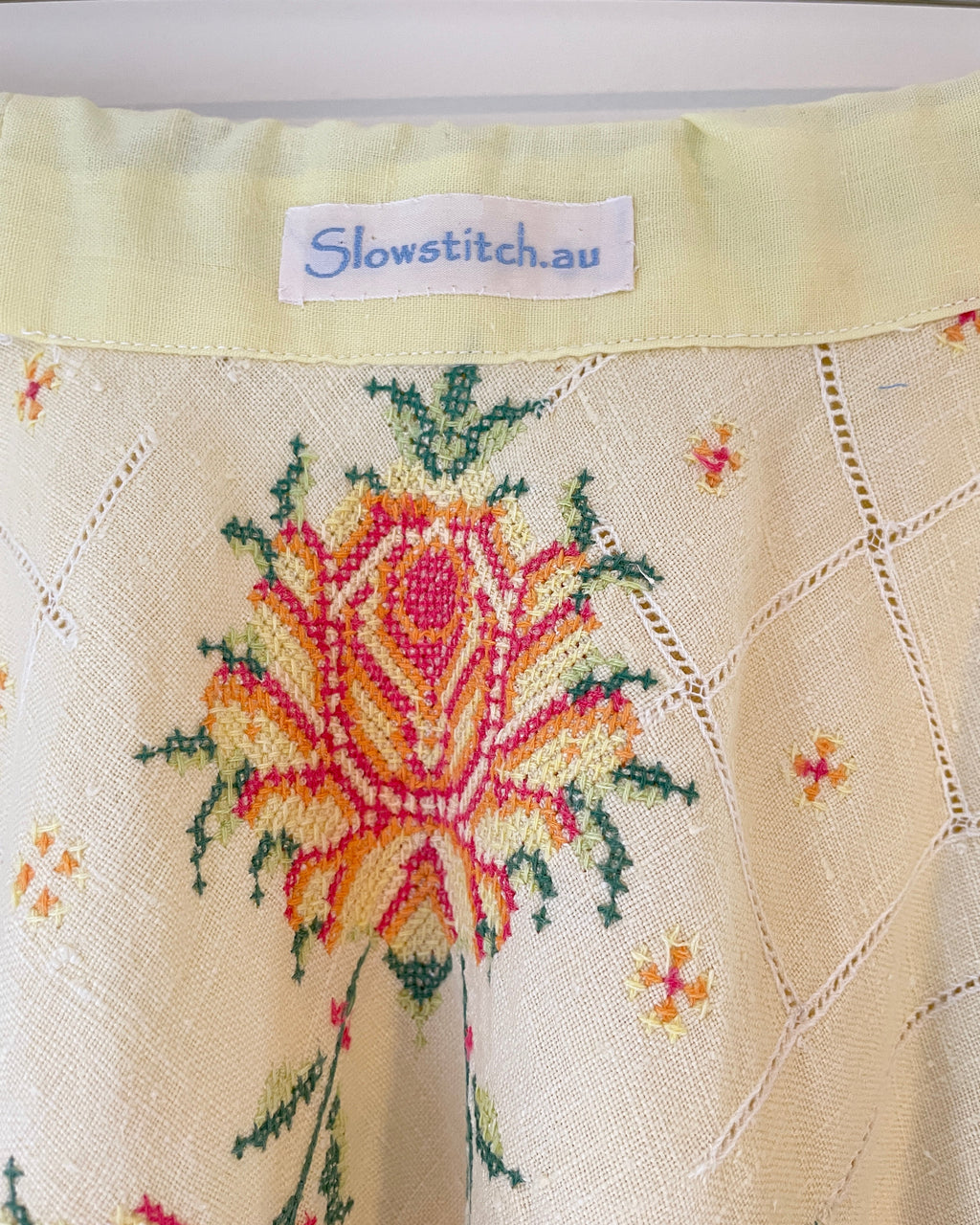 Embroidered fabric with a floral design and 'Slowstitch.au' label.