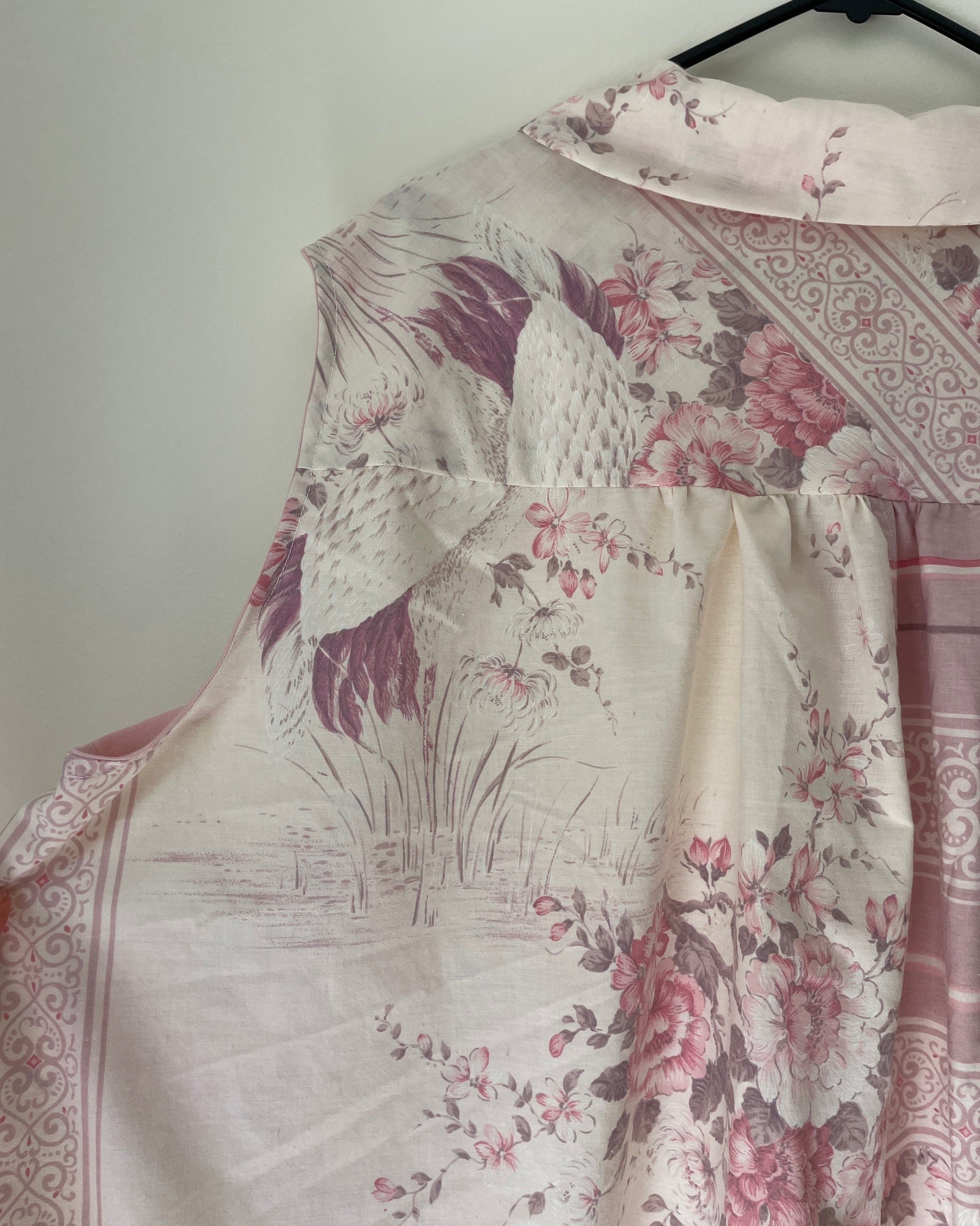 Floral patterned fabric on a hanger against a white wall