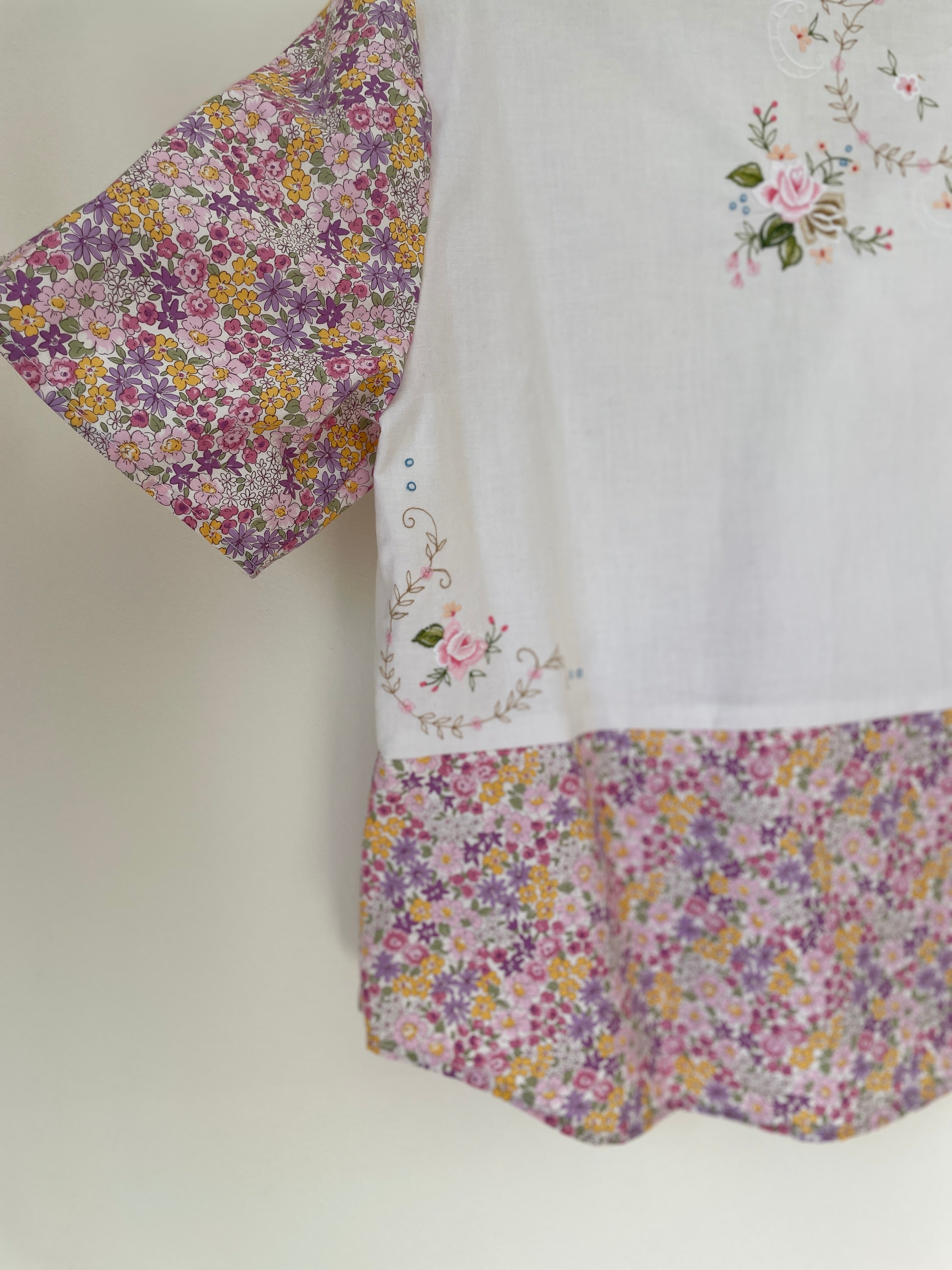 Floral-patterned fabric with embroidered details on a plain background