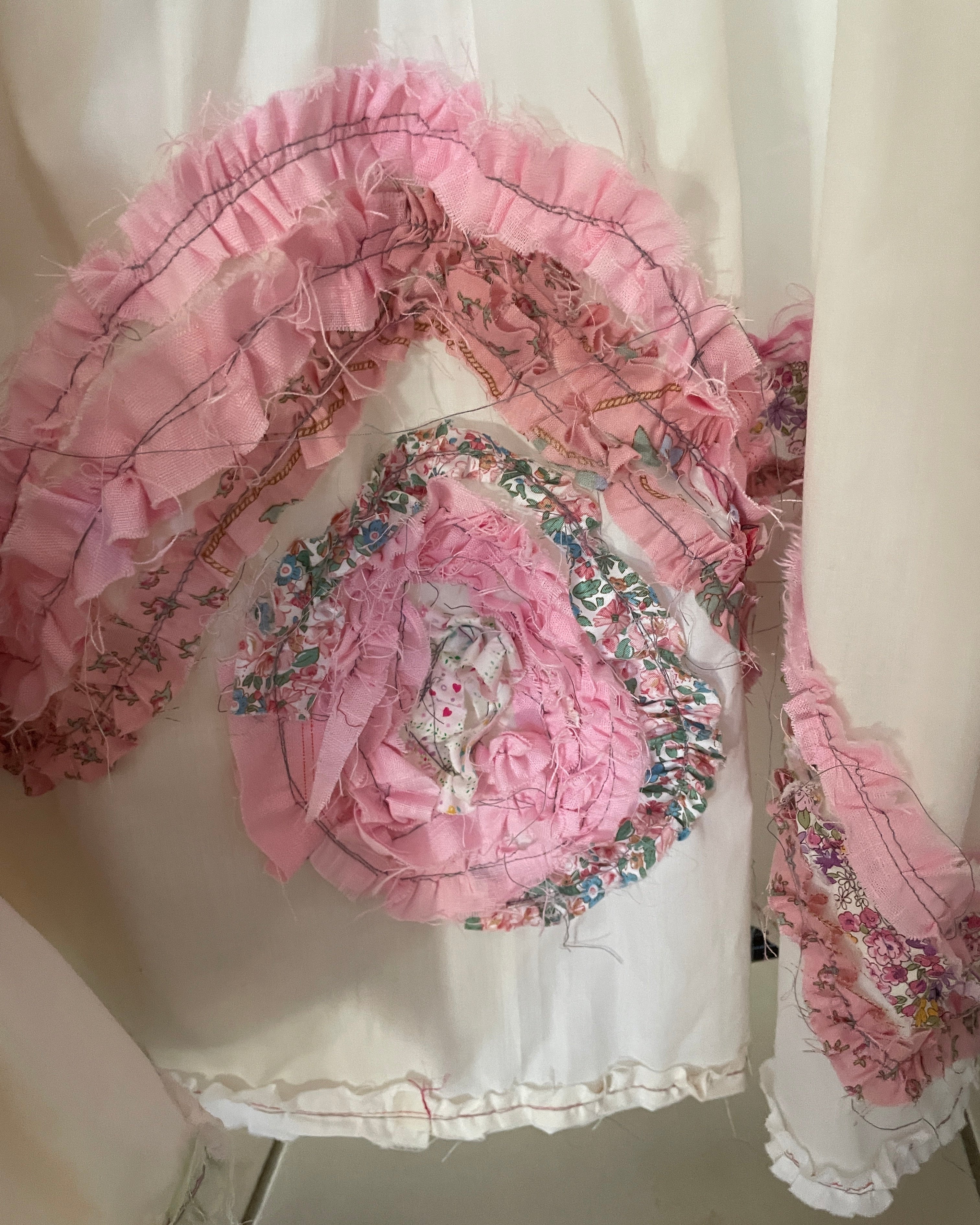 Decorative pink floral embellishments on a white dress