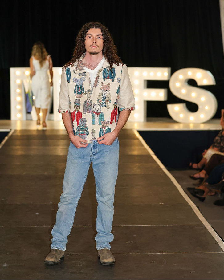Model standing on a runway with 'MVFS' letters in the background